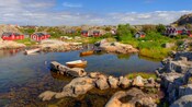 Botes en un estanque cerca de un pueblo y terreno rocoso