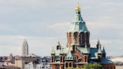 Brick building with several turrets and gold tipped spires