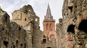 Ruinas de un antiguo edificio de ladrillo frente a una iglesia de ladrillo bien preservada