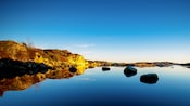 Stony coast line surrounds a placid body of water