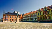 Brick 2 story buildings with surround a cobblestone plaze with a statue in the center