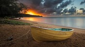 Um bote escalado com pôr do sol ao fundo
