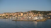 View of docked ships and a coastline with buildings and mountains