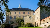 Stone, castle like building with large windows and a tower