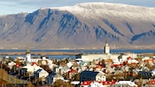 Town with buildings and large mountain in the backgroundand a body of water between them