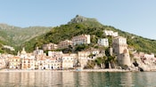 Edificios a lo largo de la costa de una gran masa de agua con colinas en el fondo
