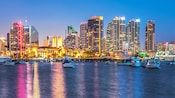 Botes en la costa de San Diego con edificios urbanos en el fondo