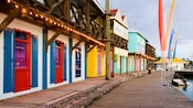 Wooden shops line a brick path next to a pier