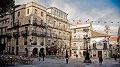 Un antiguo edificio de ladrillo de 5&nbsp;pisos, con barandillas ornamentadas y luces que cuelgan en el exterior