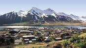 A small fishing village at the base of a stunning snowcapped mountain range along a fjord
