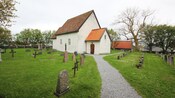 A grassy graveyard surrounds a small chapel