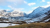 Snow covers an undeveloped valley and mountain range