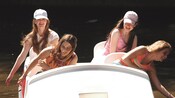4 young girls laugh and enjoy the sights while cruising through the water in a pedal boat