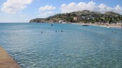 Guests swim in crystal clear water near an island beach