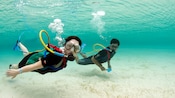 A couple poses underwater in Snuba gear