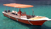 A man sits in the Captain's chair of a boat
