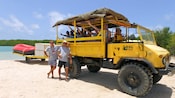 Personas sonríen y saludan en un camión de safari en la playa