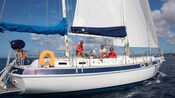 3 pessoas sentadas em um iate à vela