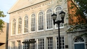 Um edifício com placas dizendo East India Marine Hall, Asiatic Bank, Oriental Insurance Office e Peabody Museum
