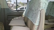 The seats of a touring van have cushions and seat covers for extra passenger comfort