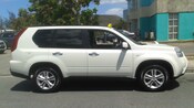 A Nissan SUV is a working taxicab parked at a curb