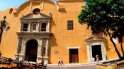 A brightly painted building of colonial architecture