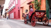 A driver sits in his horse drawn carriage on one of old town Cartagenas quaint, quiet streets