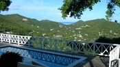Um deck de piscina com vista para casas e árvores em uma encosta
