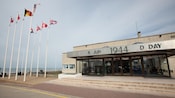 Flags near a building with a sign that reads 6 Juin 1944 D Day