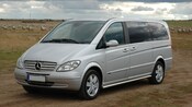 A Mercedes Benz van on a dusty country road