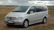 A Mercedes Benz van on a dusty country road