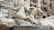 A statue of a winged horse and a god at a fountain in Rome