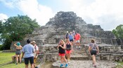 A tour group walking the stairway of a Mayan pyramid