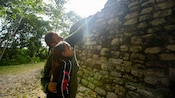 A man points something out to his young child at a Mayan temple