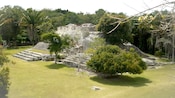 The archeological site of the Kohunlich Mayan Ruins surrounded by grass and trees