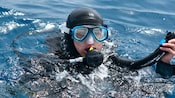 A scuba diver arrives at the surface