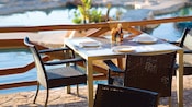 A table in an outdoor dining area sits alongside a pool