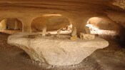 Antigua cueva con puertas naturales y artefactos sobre una mesa hecha de roca