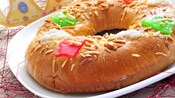 A plump, ring shaped pastry with candy, sugar sprinkles and nuts baked into it