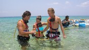 A guide shows a couple how to use their snuba diving gear