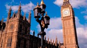 A historic cast iron lamppost stands in front of Big Ben and the Houses of Parliament in London, England