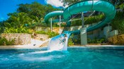 A man slides down a waterslide into a pool