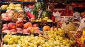 Una exhibición de frutas frescas como uvas, duraznos, sandía, fresas y peras