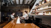 Um barman ajuda um homem em um bar