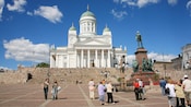 Crowds gather by statues in front of the Lutheran Cathedral in Senate Square, in Helsinkis main downtown