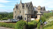 Uma placa identifica a entrada para o Loch Ness Centre & Exhibition, localizado em um grande edifício em estilo medieval