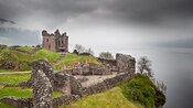 The stone ruins of Urquhart Castle by the lake on a cloudy day