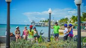 A tour guide speaking to group of cyclists near the seaside
