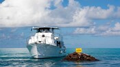 Um barco no oceano perto de uma pilha de metal com uma placa que diz Vixen No Fishing Within 100M [sem pescaria dentro de 100m]