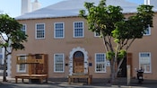 Um edifício do século XVIII com uma placa que dizia Butterfield, com estoques e pelourinhos na frente.